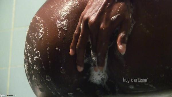 The slender black woman washing in the shower and caress her pussy